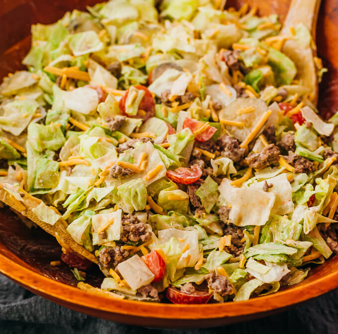 tossing big mac salad in wooden bowl