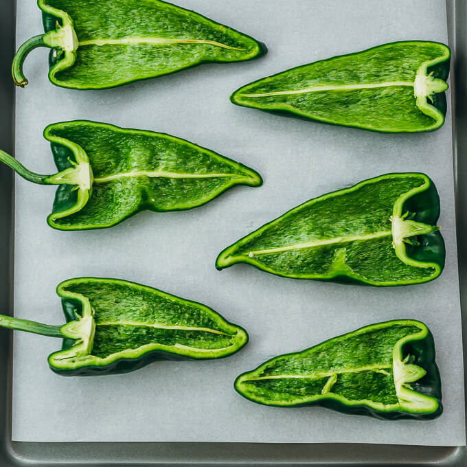 halved poblano peppers on baking sheet