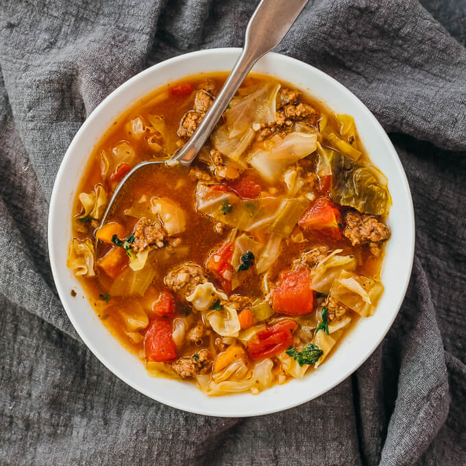 overhead view of cabbage soup served in white bowl