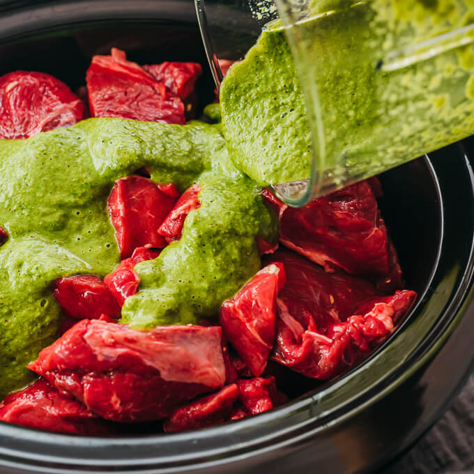 drizzling cilantro garlic sauce over lamb