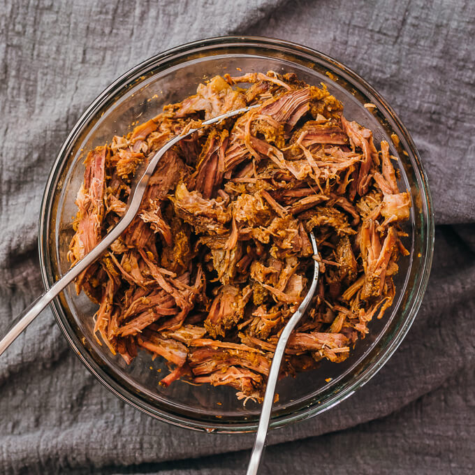 shredding cooked beef with two forks