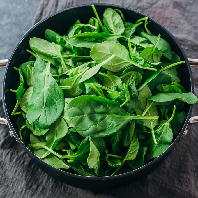raw baby spinach in nonstick pot
