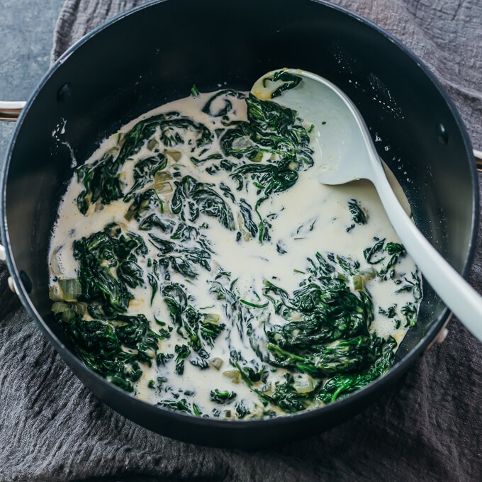 adding cream to spinach in pot
