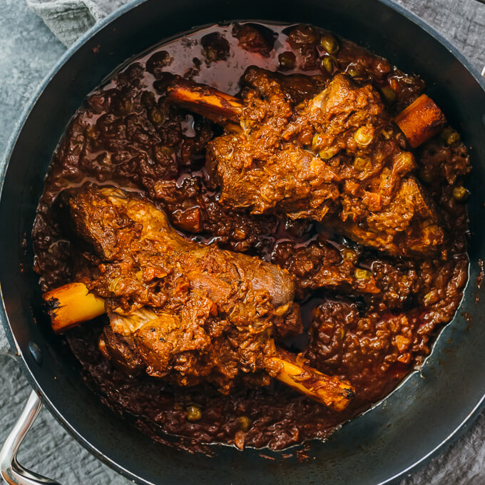 lamb shanks cooking in black pot