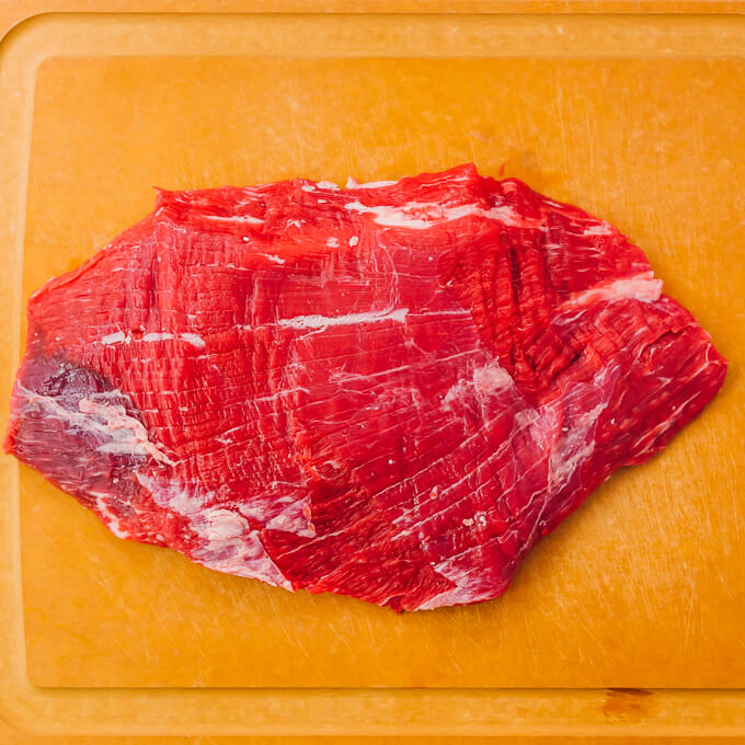 raw flank steak on cutting board