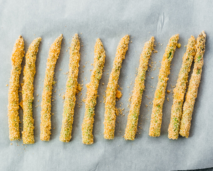 breaded asparagus spears on parchment paper