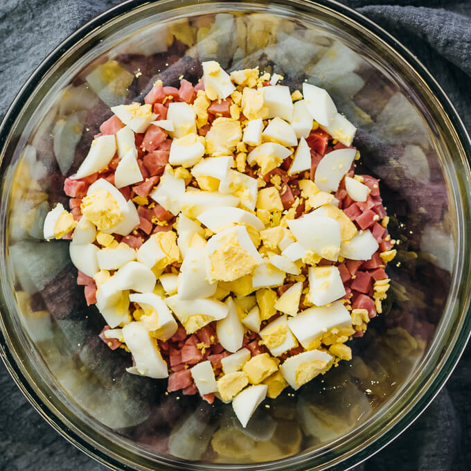 adding chopped eggs to ham salad