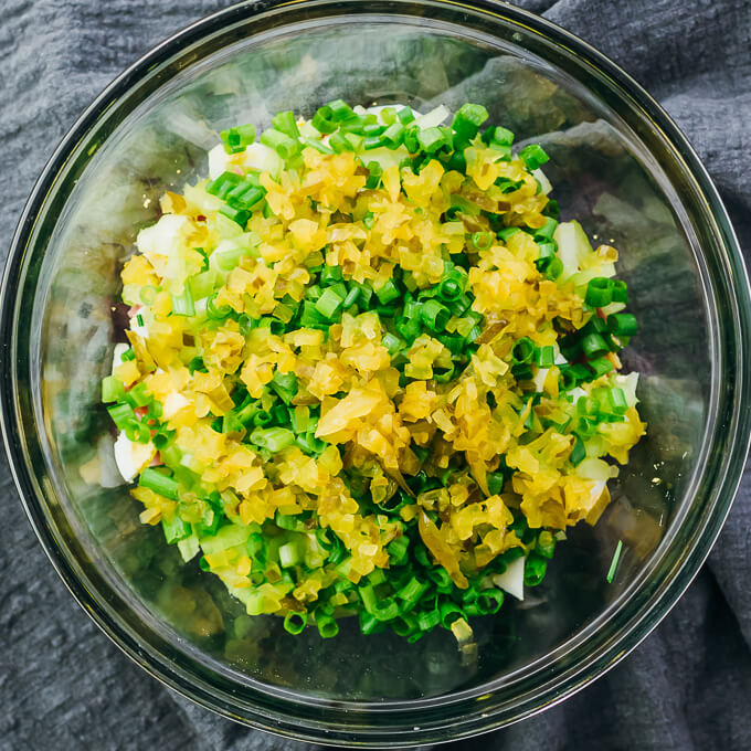 adding pickle relish and scallions to ham salad