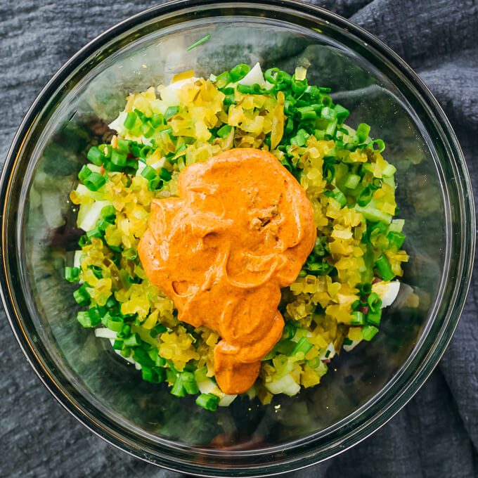 adding dressing to ham salad